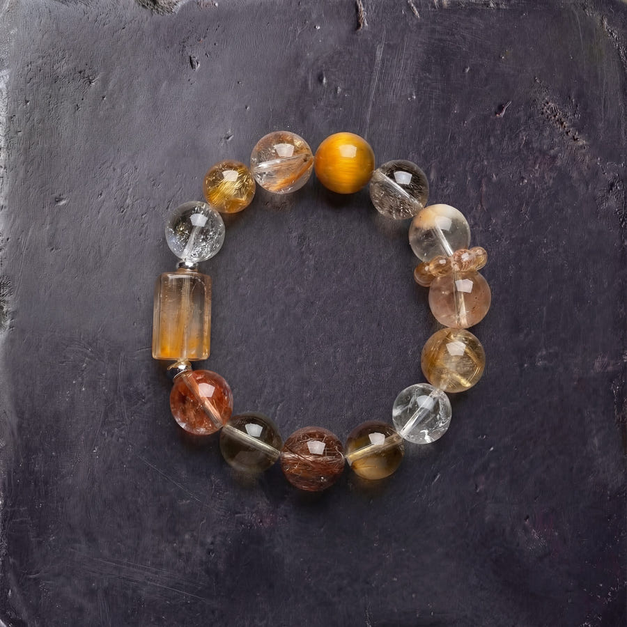 Z02 Aurum Complex bracelet — golden copper rutilated quartz and citrine beads, flat lay on dark stone