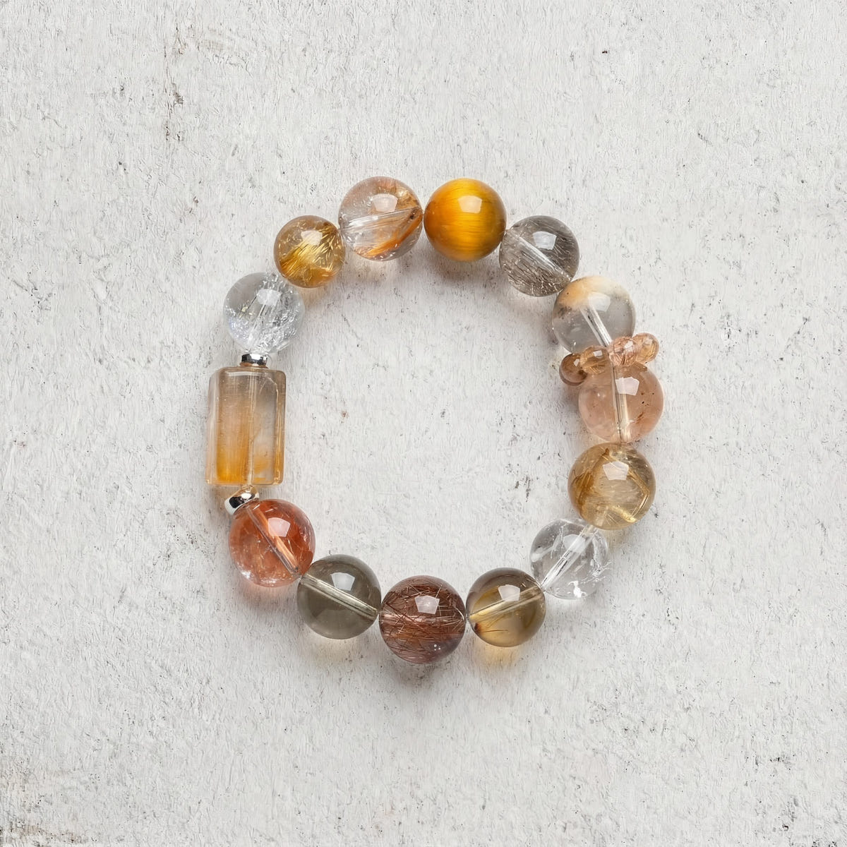 Z02 Aurum Complex bracelet top-down on light gray — amber and golden rutilated quartz beads