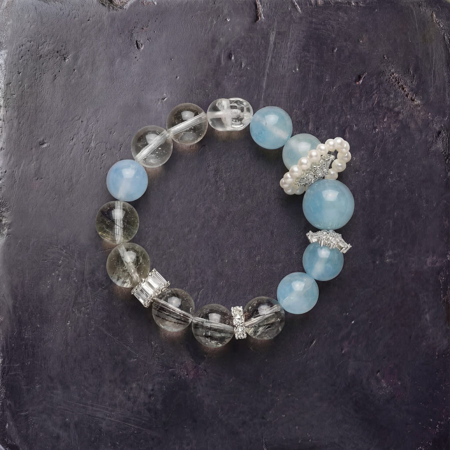 Z03 Glacial Vox bracelet — aquamarine, phantom quartz and cultured pearl accent beads, flat lay on dark stone