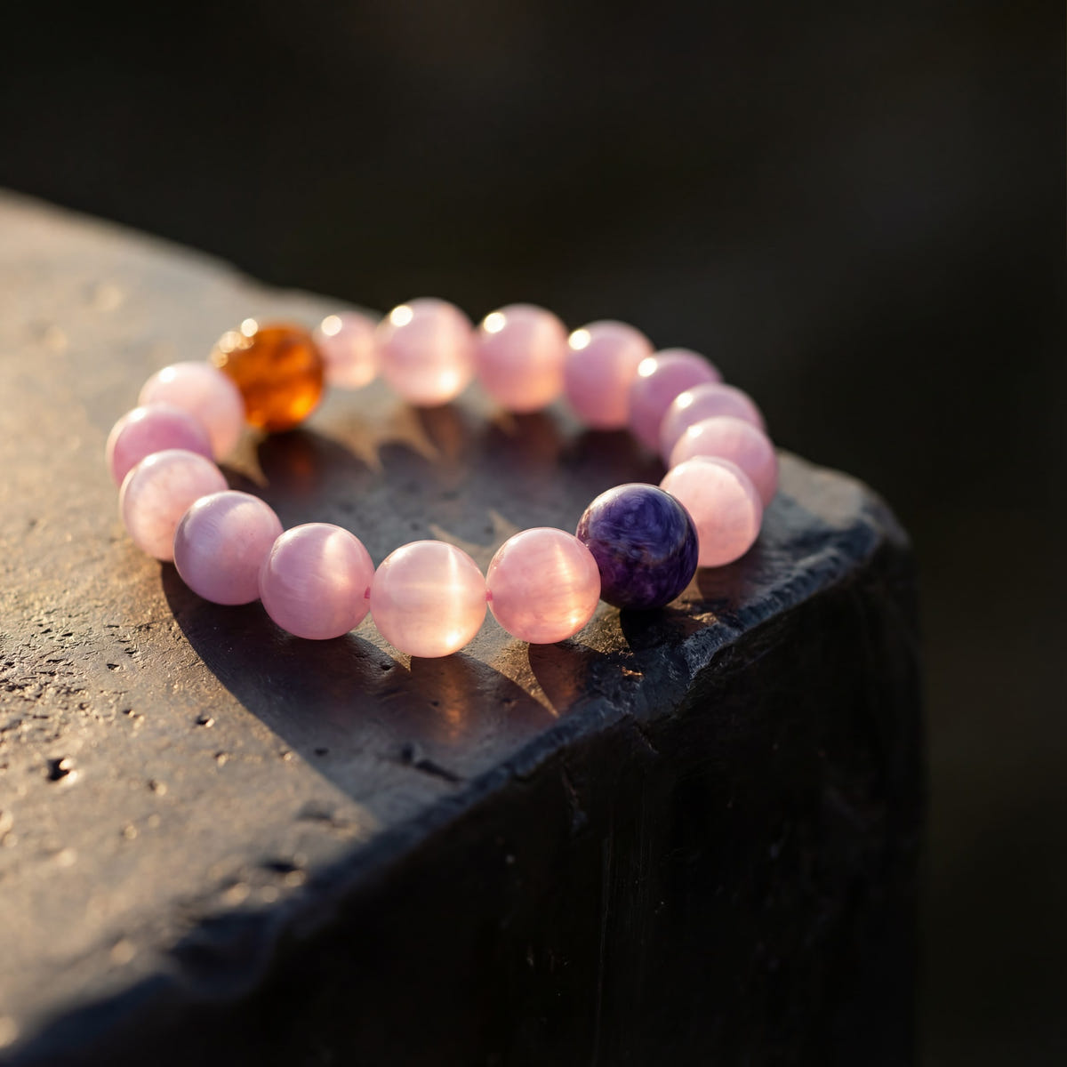 Macro of Z04 Violet Static kunzite beads in low warm light on dark stone