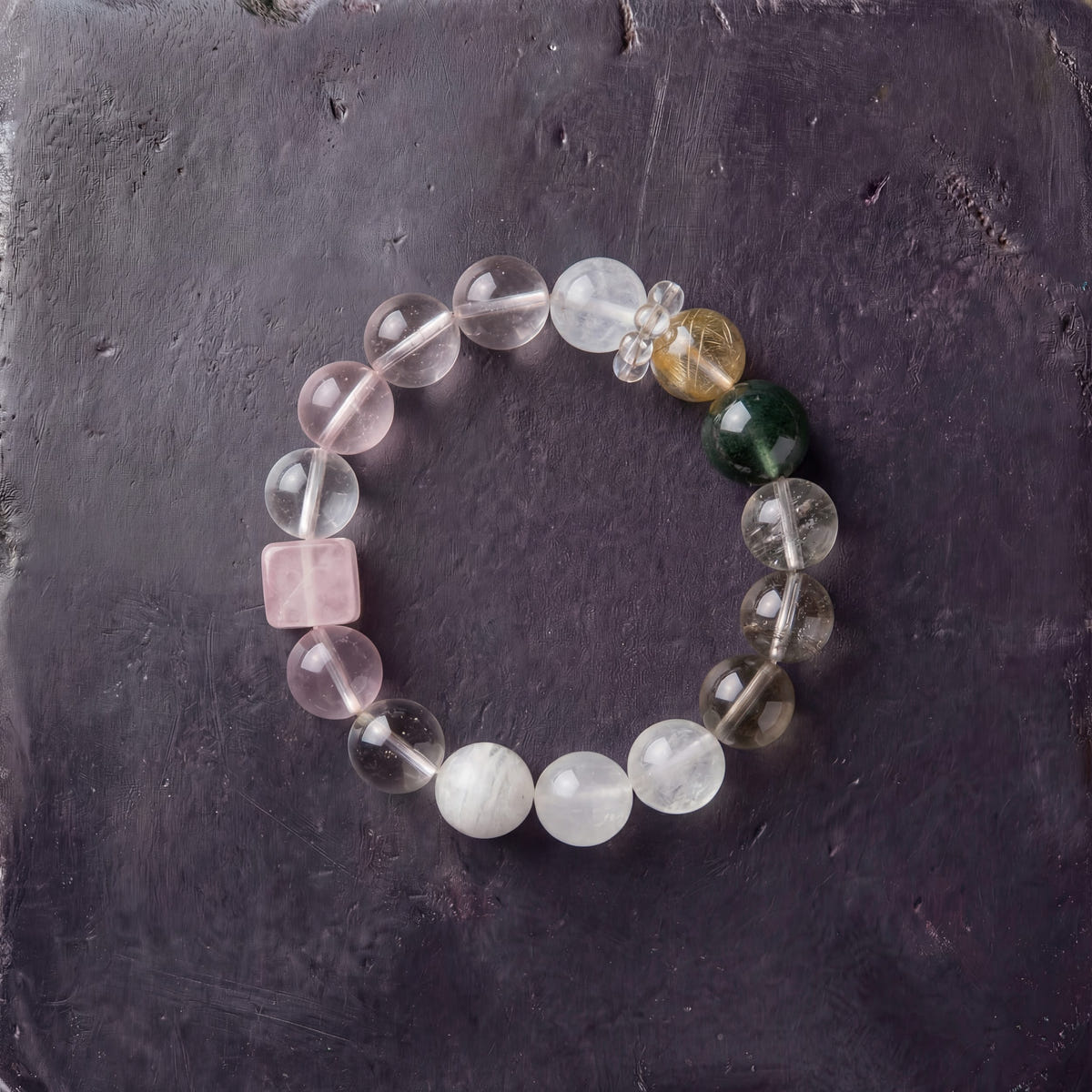 Z07 Rose Protocol bracelet — milky white and rose quartz beads with a pink cube and jade accent, flat lay on dark stone