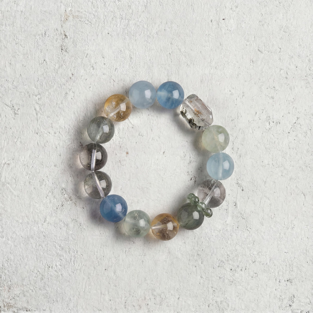Z08 Verdant Bios bracelet top-down on light gray — blue and green translucent beads